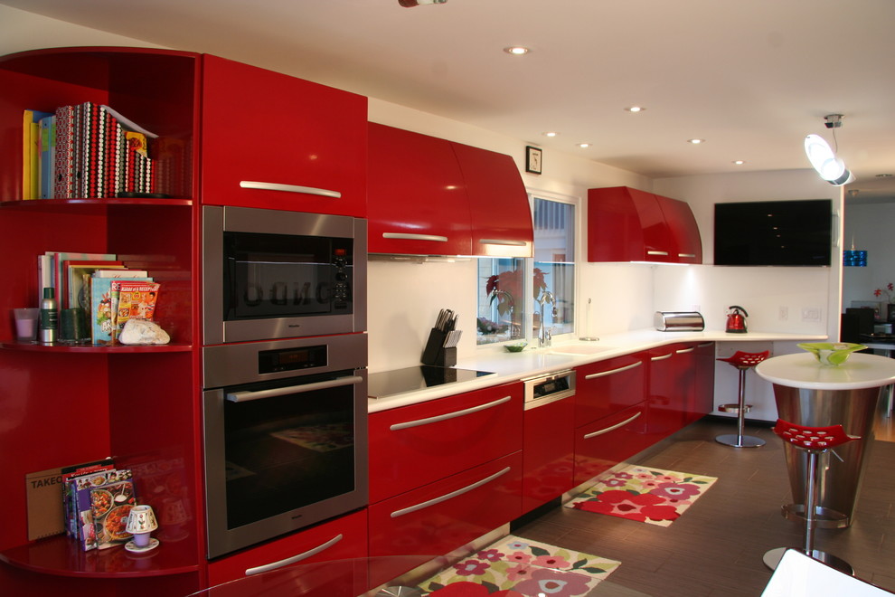 This is an example of a contemporary kitchen in Oklahoma City with stainless steel appliances and red cabinets.