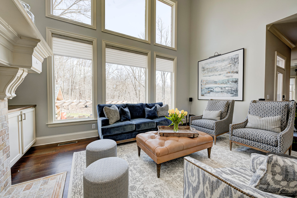 This is an example of a medium sized formal enclosed living room in Indianapolis with blue walls, medium hardwood flooring, a standard fireplace, a metal fireplace surround and a wall mounted tv.