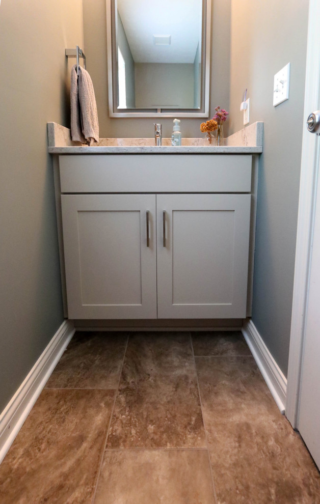Design ideas for a small transitional powder room in Cleveland with flat-panel cabinets, grey cabinets, a two-piece toilet, engineered quartz benchtops, beige floor, beige benchtops and a freestanding vanity.
