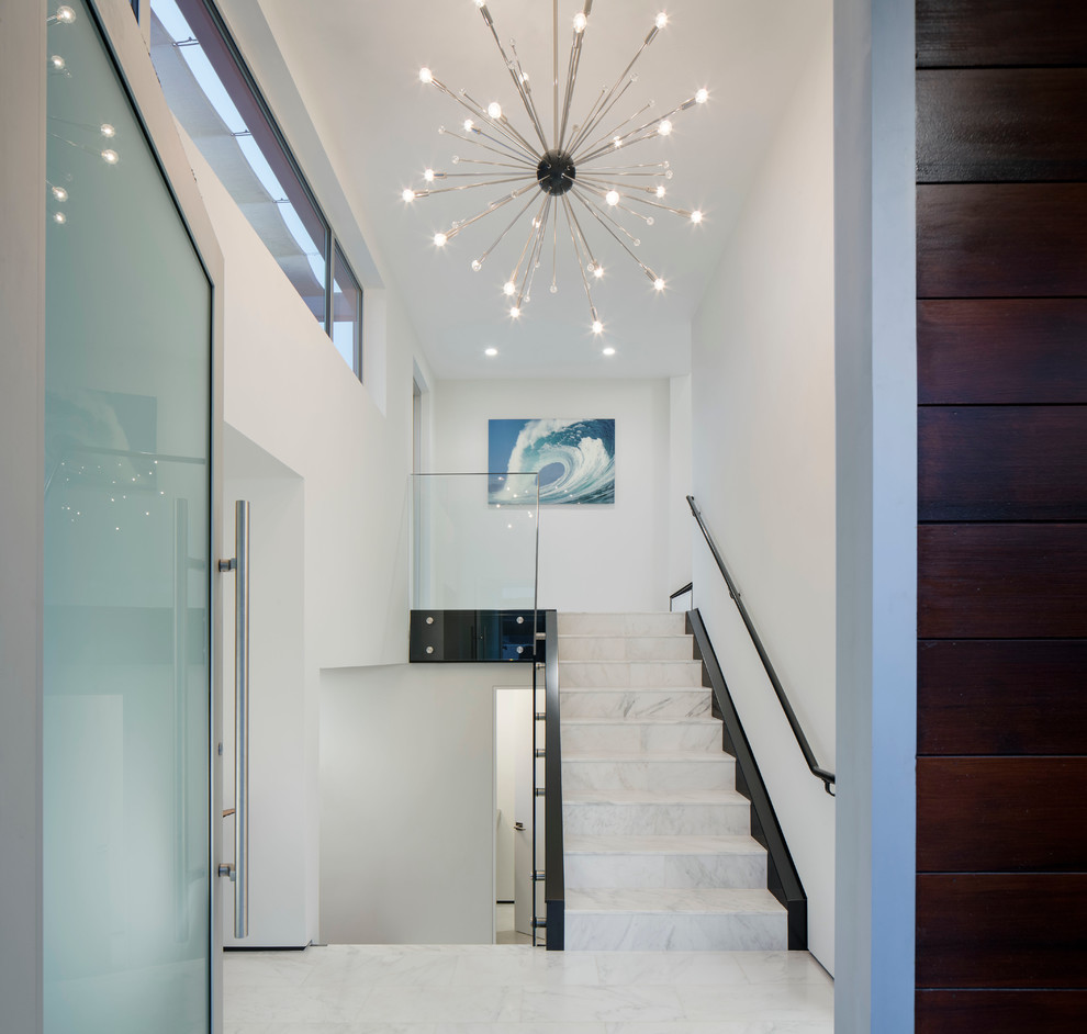 Inspiration for a contemporary foyer in San Diego with white walls, a single front door, a glass front door and marble floors.