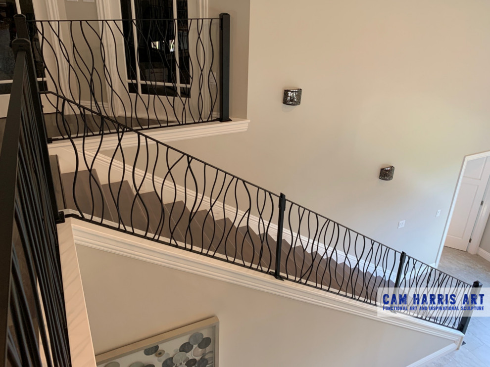 Ejemplo de escalera recta contemporánea grande con escalones de madera, contrahuellas de madera pintada y barandilla de metal
