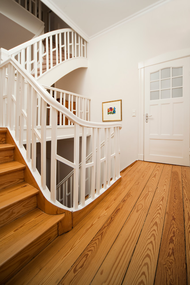 This is an example of a large traditional wood l-shaped staircase in Hamburg with wood risers.