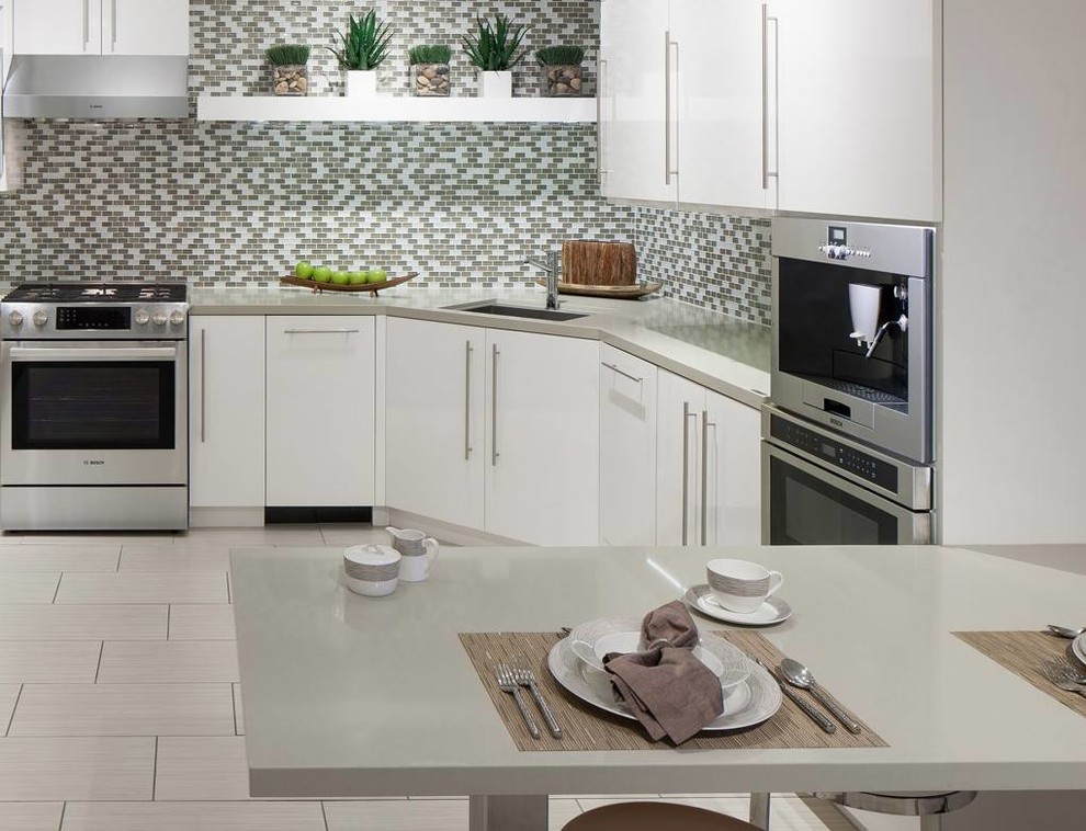 Inspiration for a mid-sized modern u-shaped eat-in kitchen in Houston with an integrated sink, flat-panel cabinets, white cabinets, quartz benchtops, multi-coloured splashback, ceramic splashback, stainless steel appliances, limestone floors and no island.