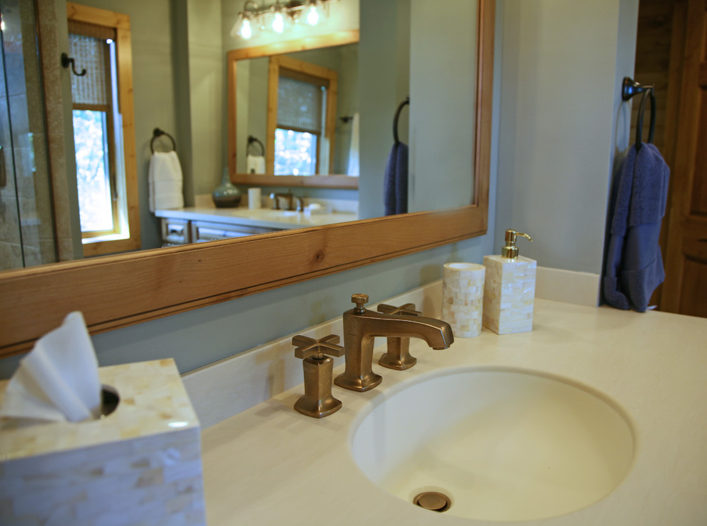 Country bathroom in Milwaukee with raised-panel cabinets, medium wood cabinets and solid surface benchtops.