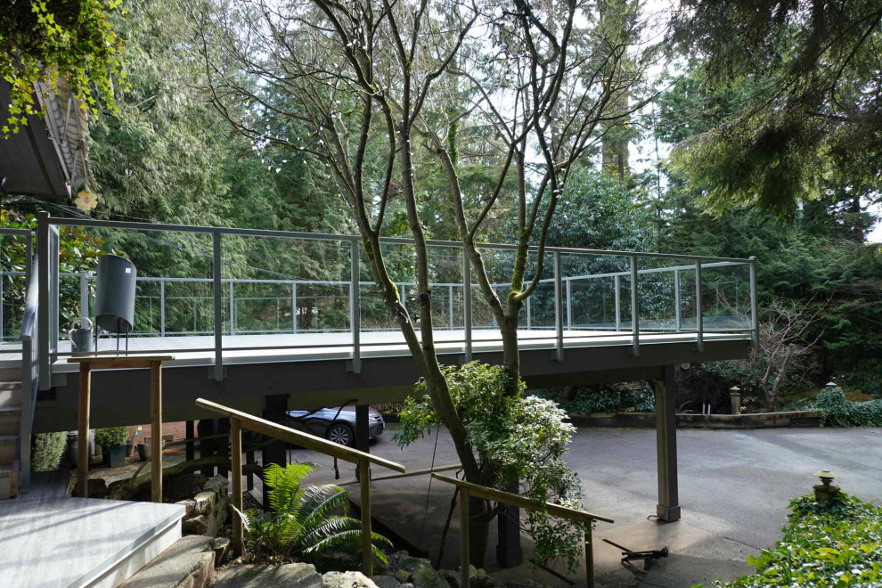 Modelo de terraza actual de tamaño medio sin cubierta en patio con barandilla de vidrio