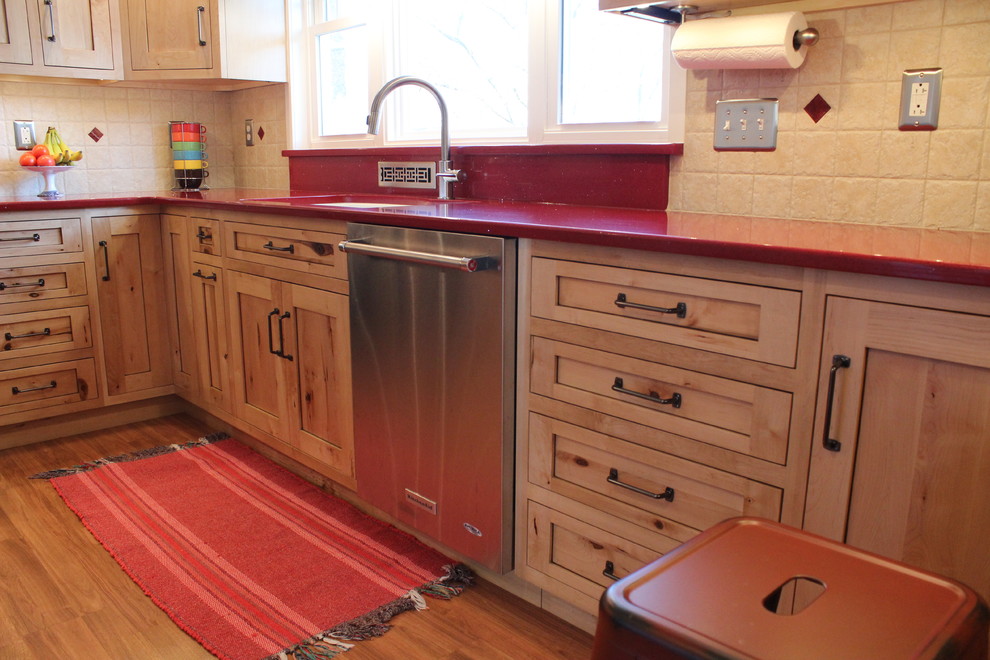 Inspiration for a mid-sized rustic l-shaped laminate floor enclosed kitchen remodel in Philadelphia with a double-bowl sink, shaker cabinets, light wood cabinets, quartz countertops, beige backsplash, ceramic backsplash, stainless steel appliances and no island