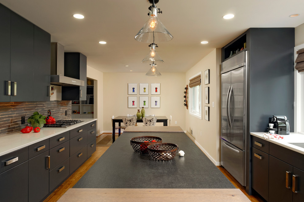 Design ideas for a large contemporary u-shaped eat-in kitchen in DC Metro with flat-panel cabinets, grey cabinets, grey splashback, stainless steel appliances, with island, an undermount sink, granite benchtops, stone slab splashback and light hardwood floors.