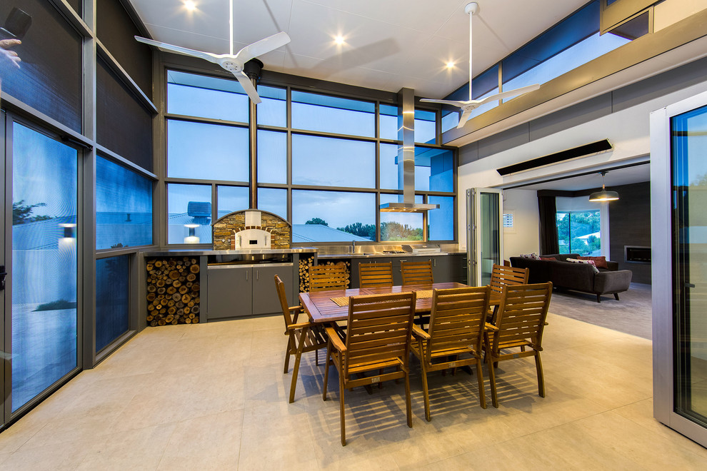 Photo of a large contemporary courtyard patio in Sydney with an outdoor kitchen, tile and a roof extension.