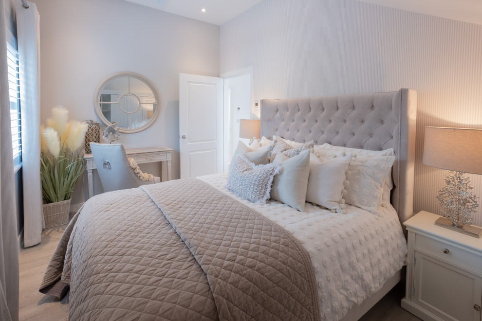 Photo of a small nautical guest bedroom in Hampshire with beige walls, laminate floors, no fireplace, grey floors and wallpapered walls.