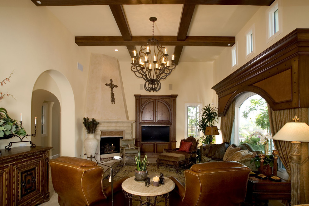 Large traditional enclosed family room in Orange County with a standard fireplace, a built-in media wall, beige walls, limestone floors, a tile fireplace surround and beige floor.