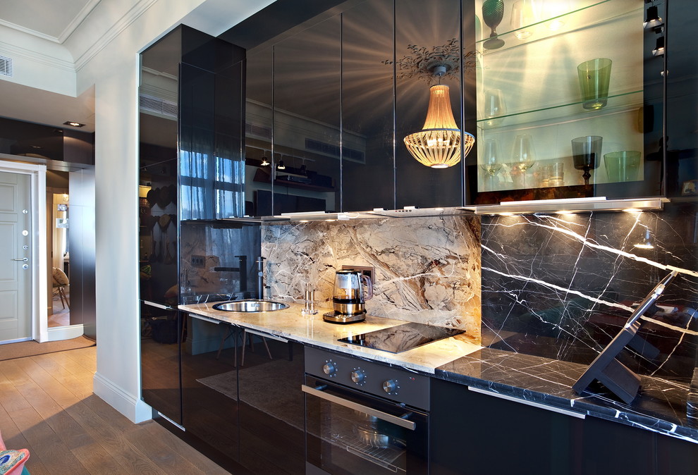 Photo of a small contemporary single-wall eat-in kitchen in Moscow with a drop-in sink, flat-panel cabinets, black cabinets, black appliances, marble benchtops, black splashback and stone slab splashback.
