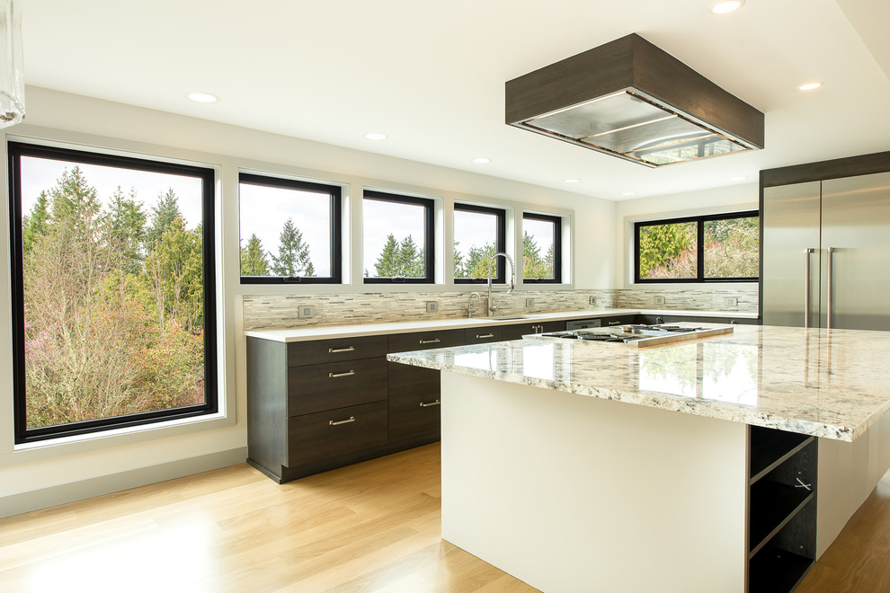 Open concept kitchen - large transitional u-shaped light wood floor and beige floor open concept kitchen idea in Seattle with an undermount sink, flat-panel cabinets, dark wood cabinets, granite countertops, gray backsplash, matchstick tile backsplash, stainless steel appliances, an island and multicolored countertops