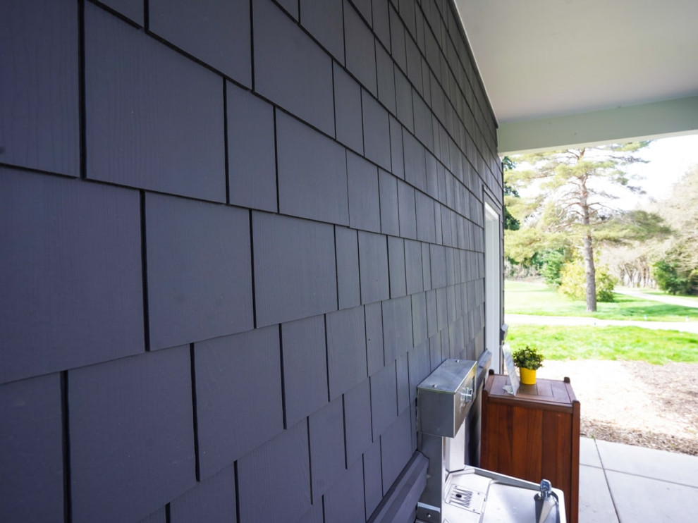 Mittelgroßes, Einstöckiges Modernes Einfamilienhaus mit Mix-Fassade, grauer Fassadenfarbe, Flachdach, Blechdach, weißem Dach und Schindeln in Seattle