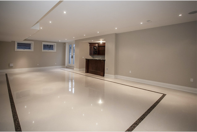 This is an example of a large traditional walk-out basement in Toronto with beige walls, porcelain floors, no fireplace and beige floor.