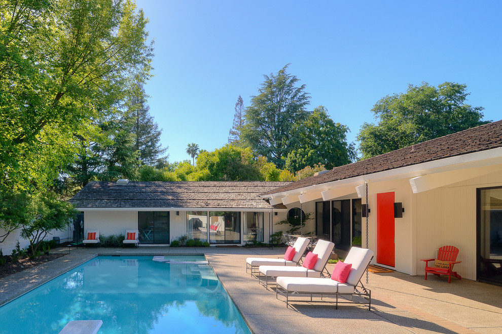 Photo of a large midcentury courtyard rectangular pool in Sacramento.