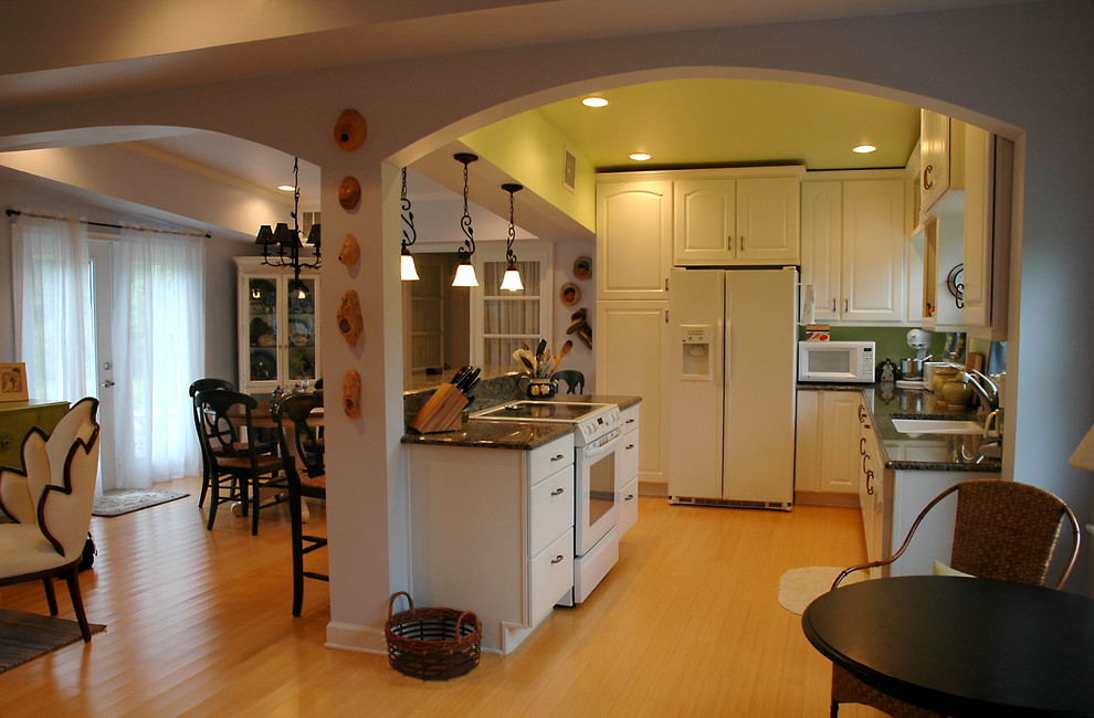 This is an example of a large eclectic l-shaped eat-in kitchen in Other with a double-bowl sink, raised-panel cabinets, white cabinets, granite benchtops, white appliances, medium hardwood floors and with island.