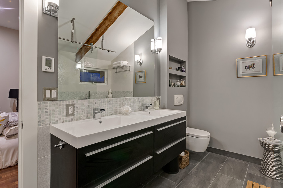 Contemporary bathroom in Calgary with flat-panel cabinets, black cabinets, a wall-mount toilet, white tile and mosaic tile.