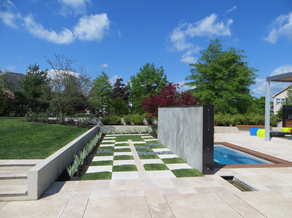 This is an example of a contemporary garden in Philadelphia with a water feature.
