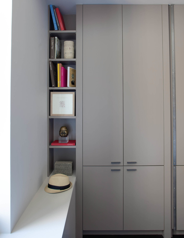 This is an example of a contemporary storage and wardrobe in New York with flat-panel cabinets.