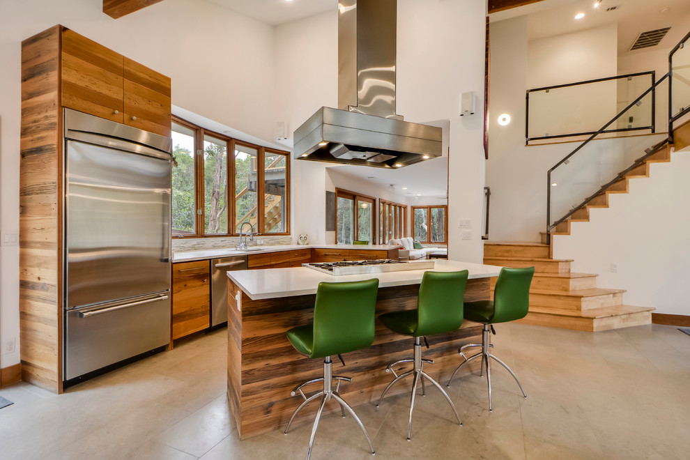 Inspiration for a mid-sized contemporary l-shaped open plan kitchen in Austin with flat-panel cabinets, medium wood cabinets, stainless steel appliances, with island, an undermount sink, quartzite benchtops and travertine floors.