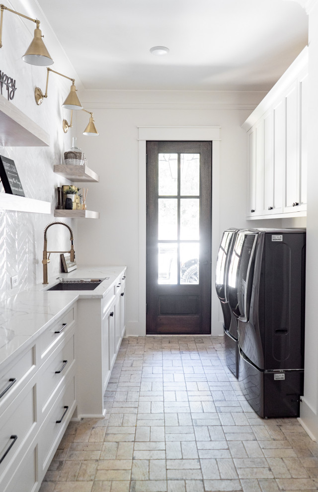 Inspiration for a mid-sized transitional galley utility room in Atlanta with an undermount sink, shaker cabinets, white cabinets, quartz benchtops, white splashback, ceramic splashback, brick floors, a side-by-side washer and dryer and white benchtop.