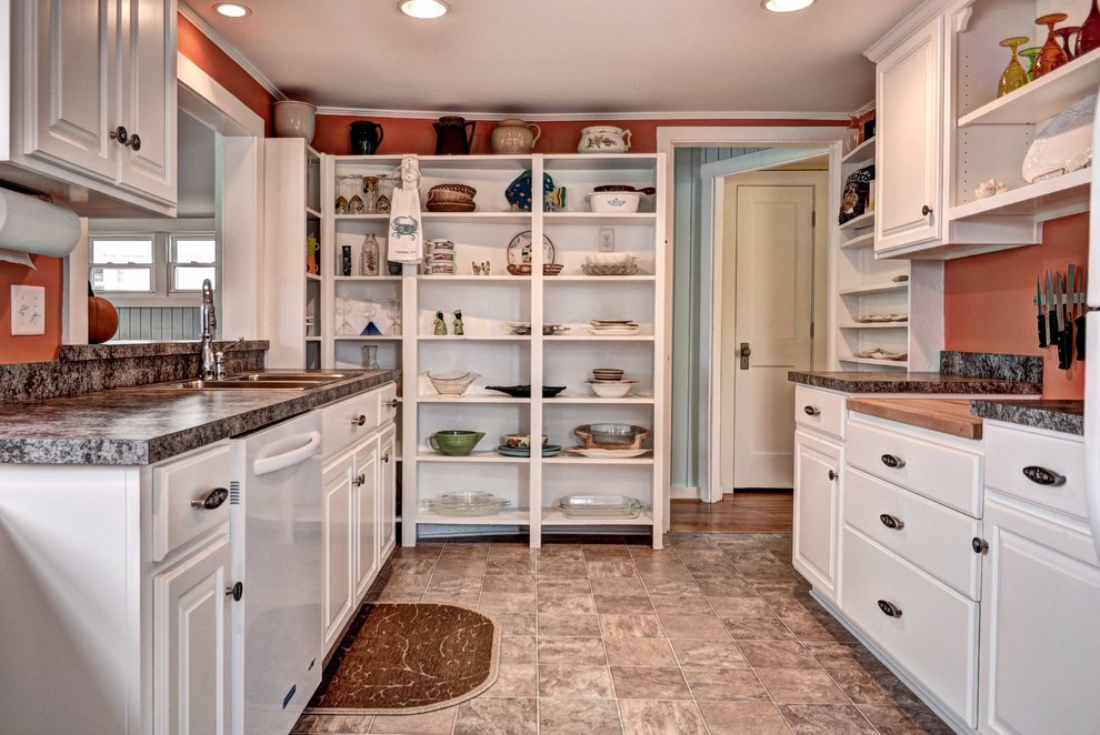 Small beach style galley separate kitchen in Other with a double-bowl sink, raised-panel cabinets, white cabinets, granite benchtops, white appliances, ceramic floors, no island and brown floor.