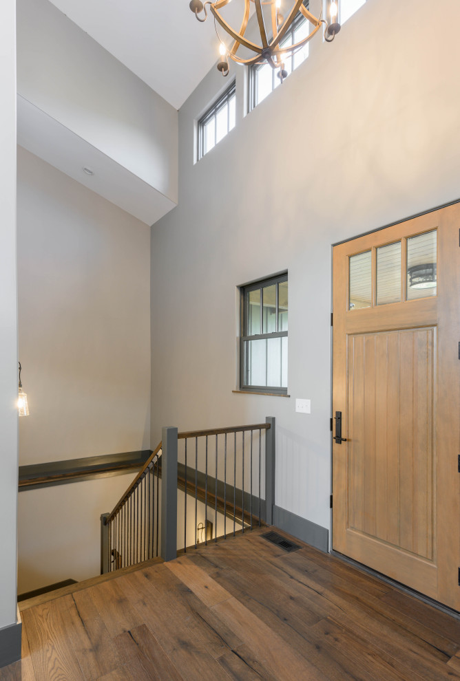 Example of a transitional medium tone wood floor and brown floor front door design with gray walls and a medium wood front door