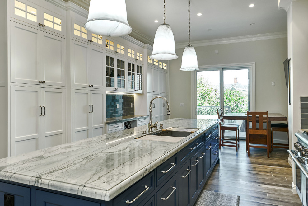 Photo of a large traditional u-shaped kitchen pantry in San Francisco with a triple-bowl sink, beaded inset cabinets, white cabinets, quartzite benchtops, blue splashback, ceramic splashback, panelled appliances, porcelain floors, with island, grey floor and blue benchtop.