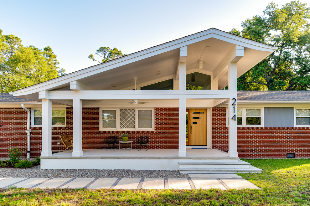 This is an example of a mid-sized midcentury front yard verandah in Other with concrete pavers and a roof extension.