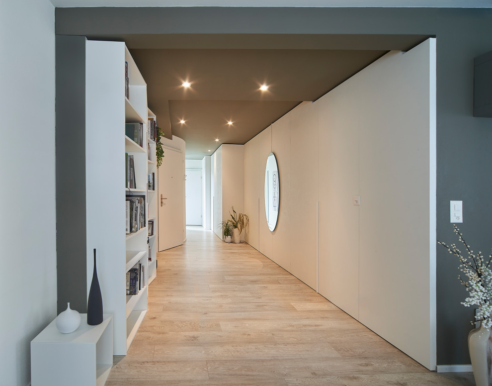 Inspiration för en mellanstor funkis hall, med grå väggar och ljust trägolv