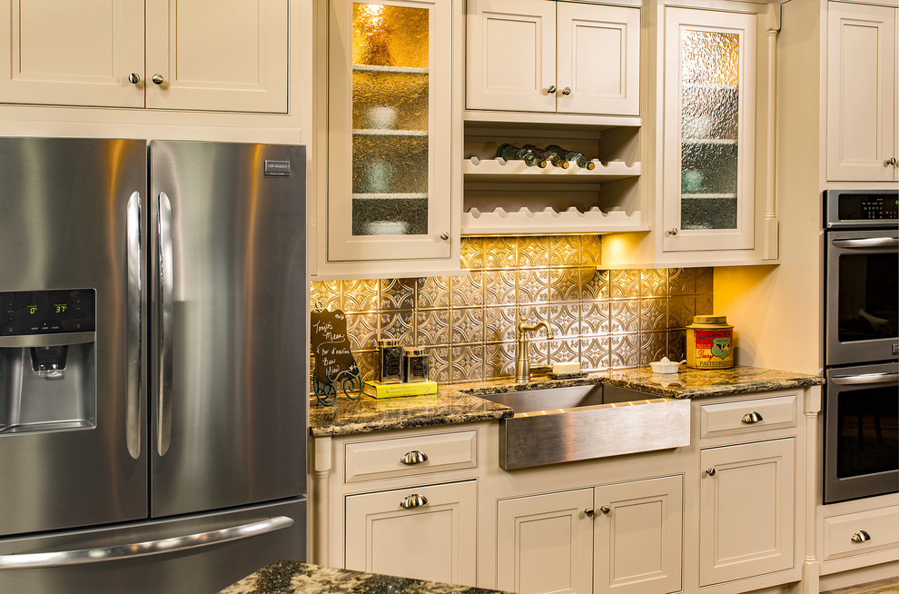 Inspiration for a mid-sized timeless kitchen remodel with a farmhouse sink, beaded inset cabinets, white cabinets, granite countertops, metallic backsplash, metal backsplash and stainless steel appliances