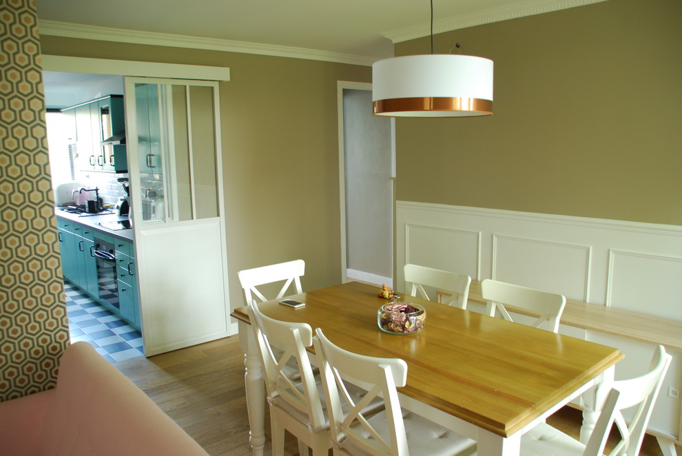 Photo of a small midcentury dining room in Paris with beige walls and light hardwood floors.