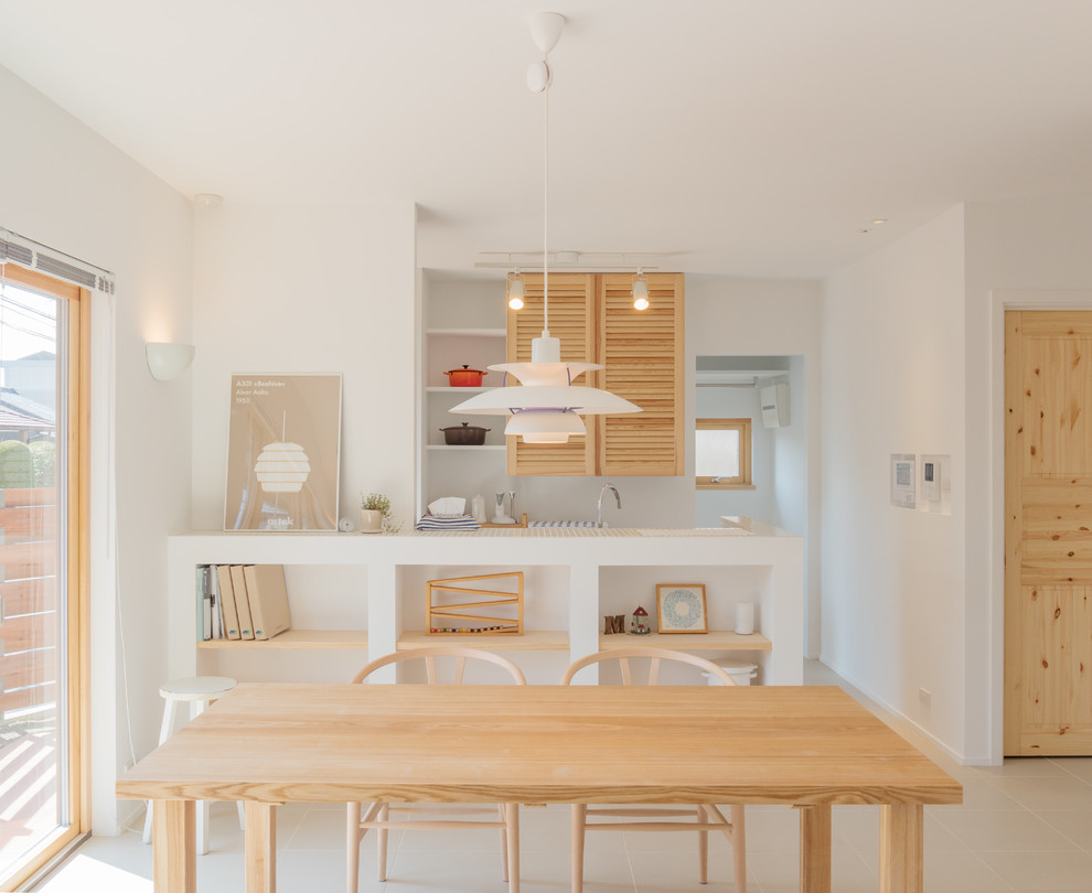 Photo of a scandinavian dining room in Other with white walls and beige floor.