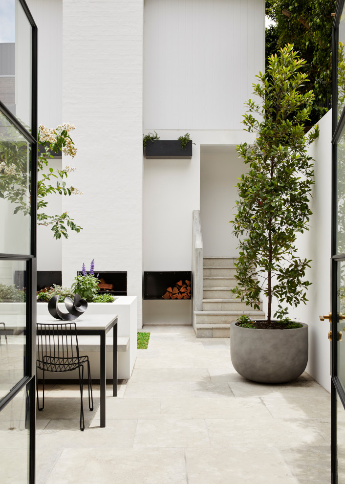 Пример оригинального дизайна: маленький двор на внутреннем дворе в стиле неоклассика (современная классика) с покрытием из каменной брусчатки для на участке и в саду