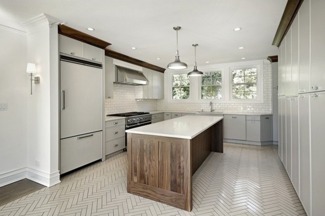 Photo of a mid-sized transitional l-shaped separate kitchen in Chicago with flat-panel cabinets, white cabinets, stainless steel appliances, with island, an undermount sink, quartz benchtops, white splashback, glass tile splashback and ceramic floors.