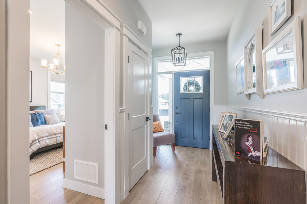 Design ideas for a mid-sized transitional entry hall in Vancouver with grey walls, laminate floors, a single front door, a blue front door, beige floor and decorative wall panelling.