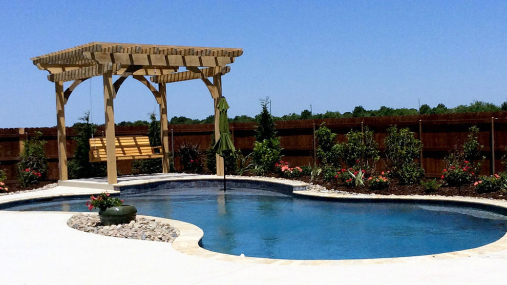 This is an example of a mid-sized traditional backyard pool in Orange County with concrete pavers.