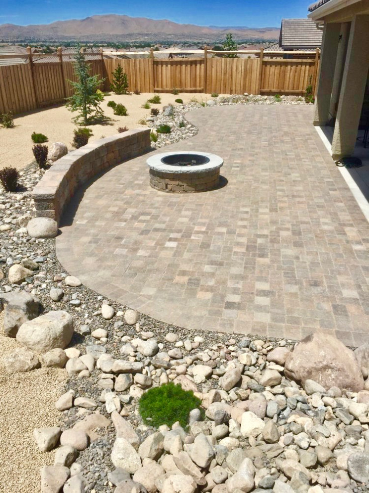 Inspiration for a mid-sized traditional backyard full sun xeriscape for fall in Las Vegas with a fire feature and natural stone pavers.