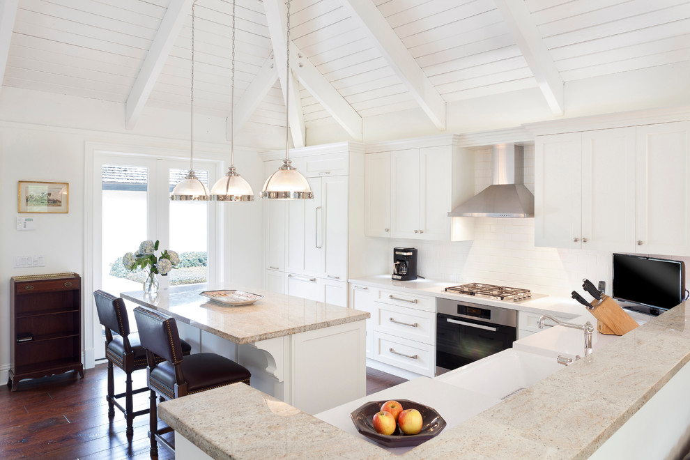 Eat-in kitchen - mid-sized transitional l-shaped dark wood floor and brown floor eat-in kitchen idea in Miami with dark wood cabinets, stainless steel appliances, a drop-in sink, recessed-panel cabinets, marble countertops, white backsplash, porcelain backsplash, an island and beige countertops