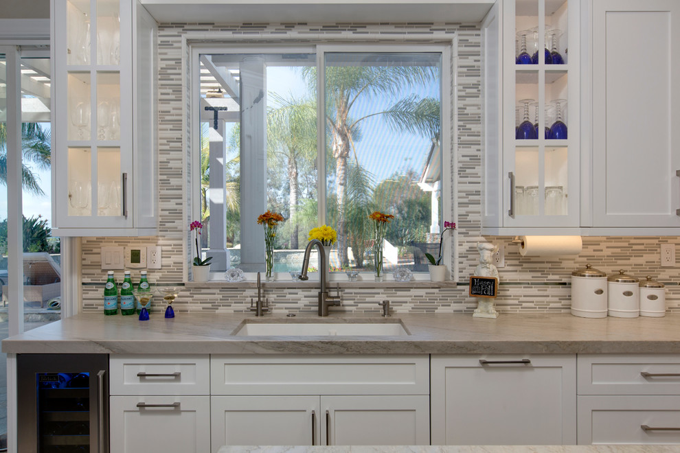 Mid-sized transitional u-shaped kitchen pantry in San Diego with an undermount sink, recessed-panel cabinets, white cabinets, quartzite benchtops, grey splashback, cement tile splashback, stainless steel appliances, porcelain floors and with island.