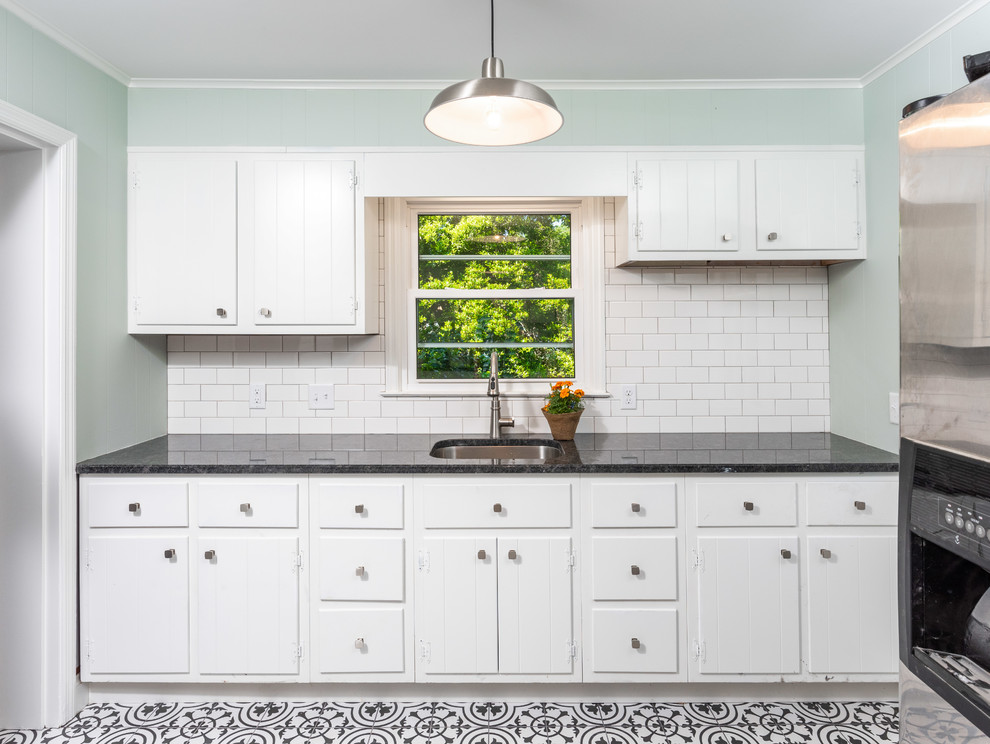 Expansive country u-shaped utility room in Other with an undermount sink, flat-panel cabinets, white cabinets, granite benchtops, green walls, ceramic floors, a side-by-side washer and dryer, multi-coloured floor and black benchtop.