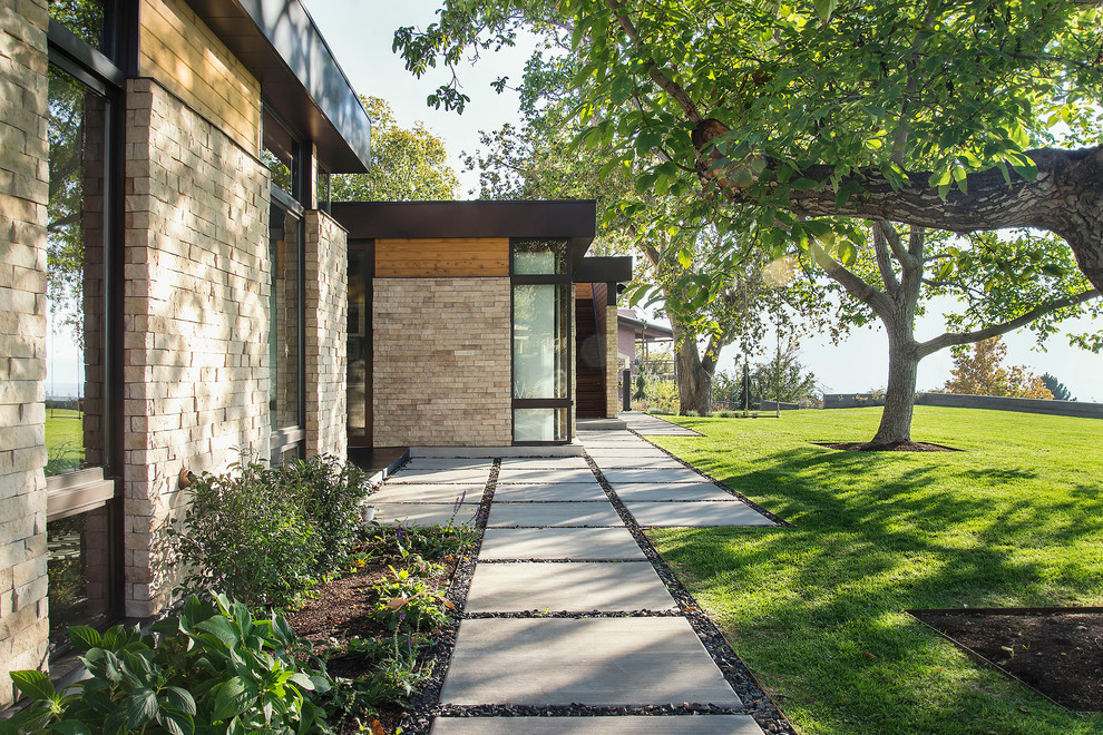 Design ideas for a mid-sized modern one-storey exterior in Salt Lake City with stone veneer and a flat roof.