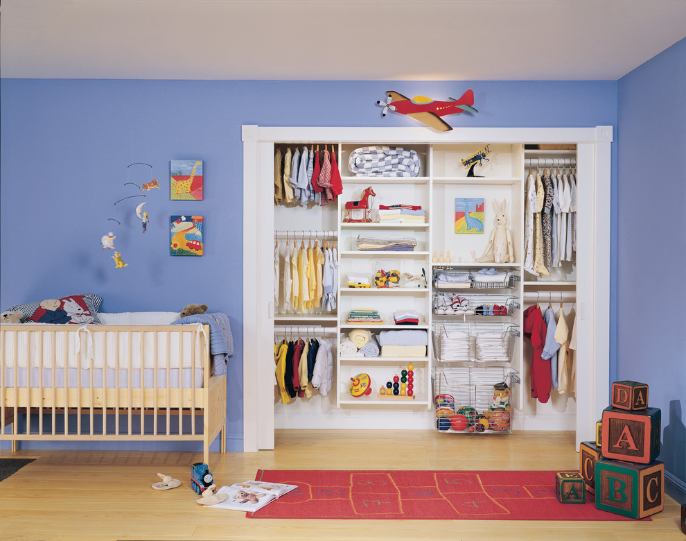 Photo of a mid-sized traditional nursery for boys in Austin with blue walls and light hardwood floors.