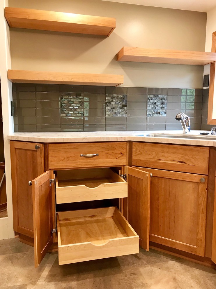 Small transitional galley beige floor eat-in kitchen photo with an undermount sink, recessed-panel cabinets, light wood cabinets, solid surface countertops, brown backsplash, glass tile backsplash, stainless steel appliances and multicolored countertops