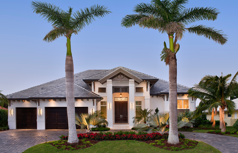 Design ideas for a transitional one-storey stucco white house exterior in Miami with a hip roof and a tile roof.
