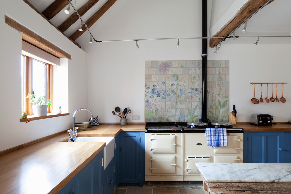 Inspiration for a country l-shaped eat-in kitchen in Sussex with a farmhouse sink, blue cabinets, wood benchtops and coloured appliances.