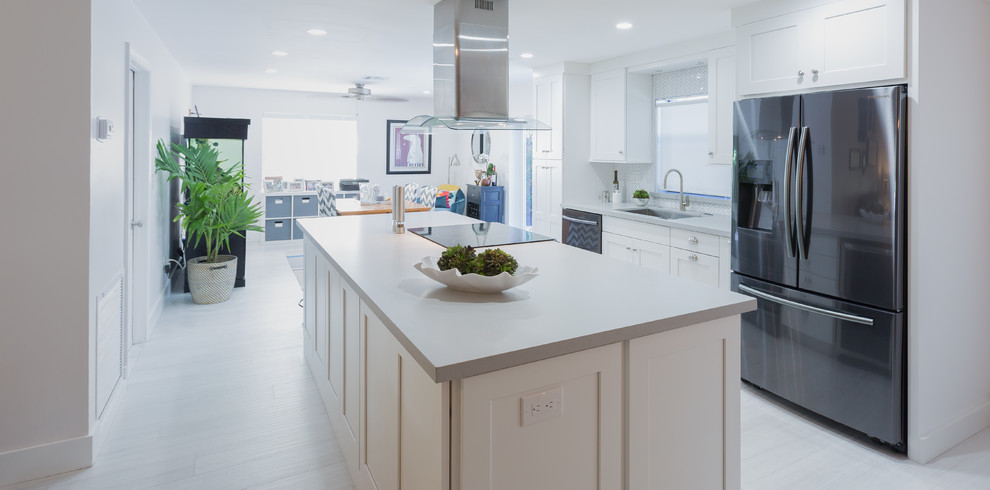 Open concept kitchen - small transitional single-wall porcelain tile open concept kitchen idea in Miami with an undermount sink, shaker cabinets, white cabinets, quartz countertops, white backsplash and an island