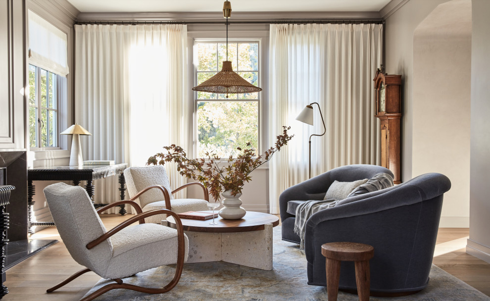 Foto di un soggiorno chic con pareti beige, parquet chiaro, camino classico e pavimento beige