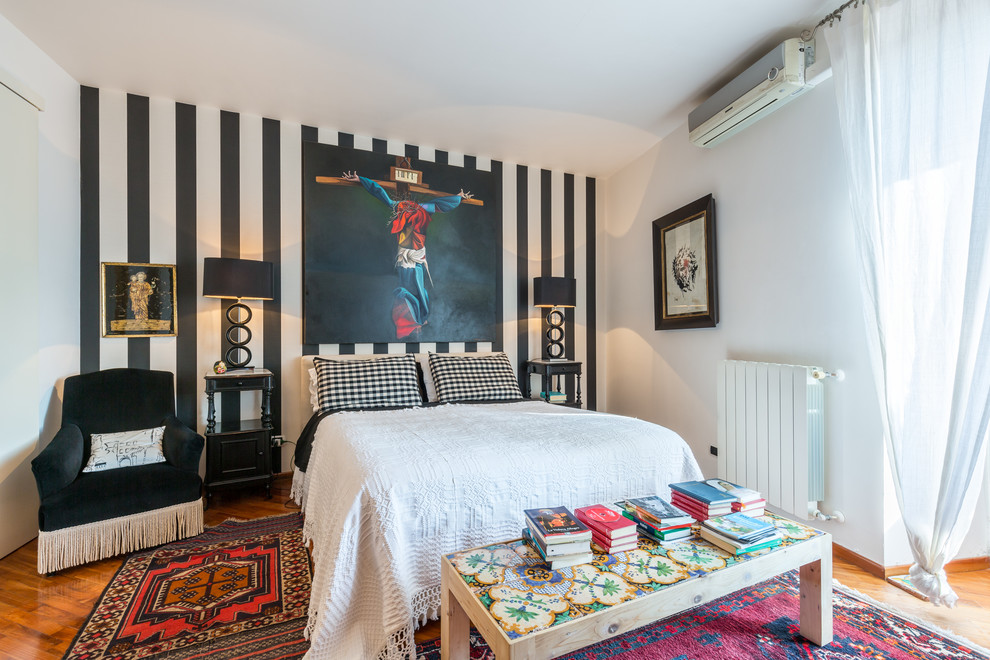 This is an example of a mediterranean master bedroom in Catania-Palermo with multi-coloured walls and medium hardwood floors.