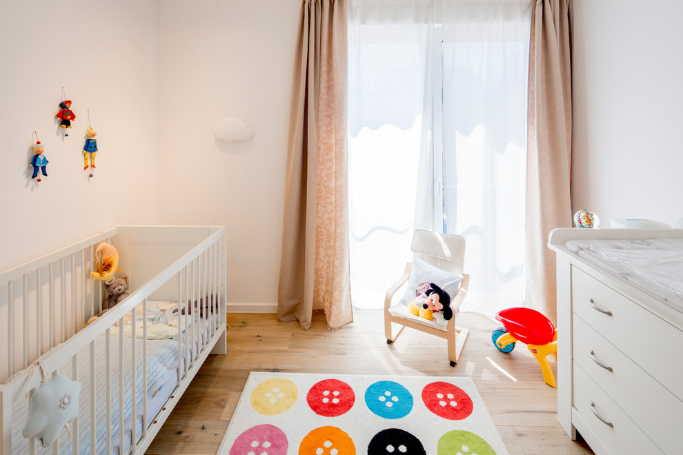 Babyzimmer With Schlafplatz, weißer Wandfarbe, braunem Holzboden and beigem Boden in Dusseldorf